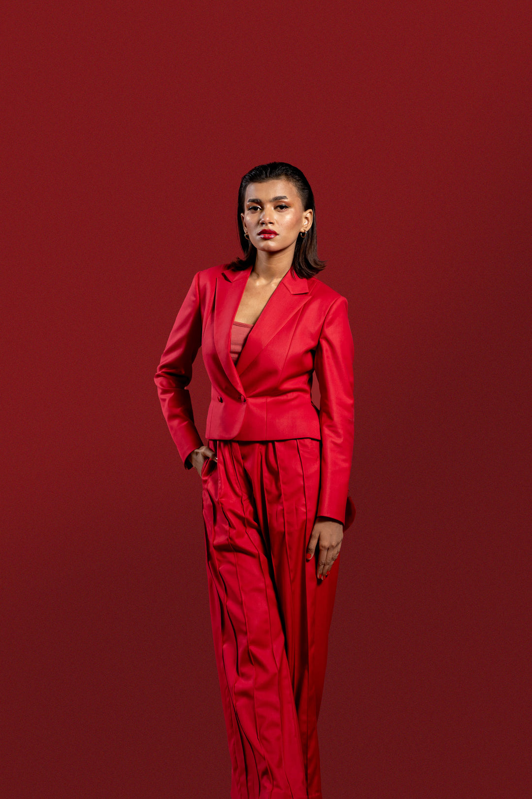 Modern Red 2-Piece Suit for Women: Pleated Pants & Long Tail Crop Blazer.